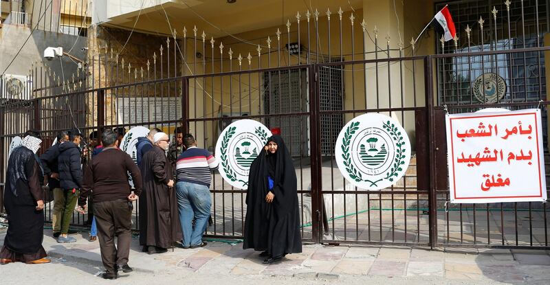 Customers gather outside a bank after it was closed during a nationwide strike, in Baghdad. Reuters