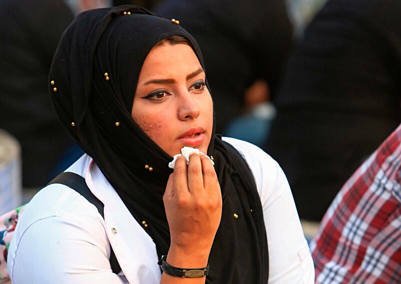 In this Tuesday, Sept. 18, 2018 photo, Hajar Youssif, an Iraqi activist and volunteer medic, who was kidnapped, beaten and threatened for attending protests, sits with protesters in Basra, Iraq. Youssif said the beating left her shaken and that threats continue, but she wonâ€™t be deterred. Activists say powerful Iranian-backed militias that control Iraqâ€™s oil capital of Basra have waged a campaign of intimidation and arbitrary arrests to silence protests aimed at poor government services and Tehranâ€™s outsized influence in the region. (AP Photo/Nabil al-Jurani)