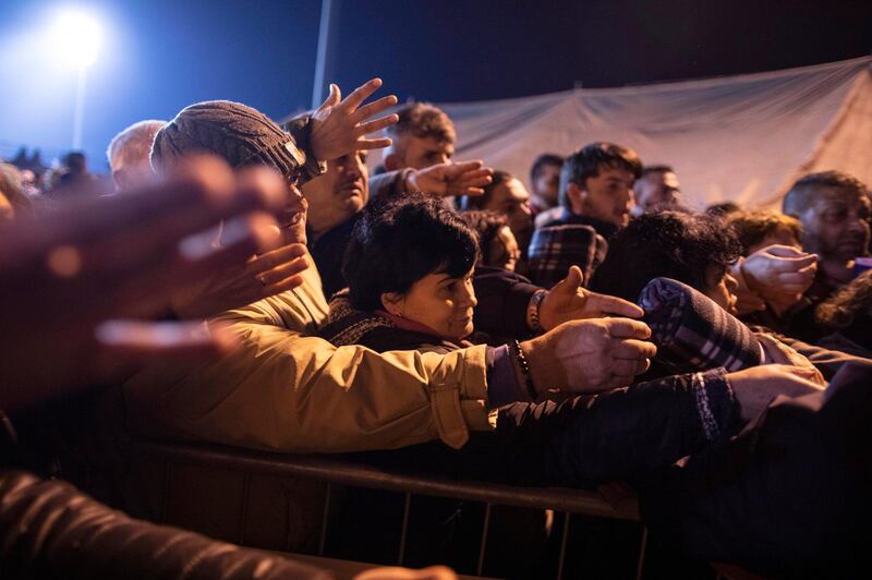 People gather to receive blankets provided by volunteers at a makeshift camp in a soccer field, following a deadly earthquake in Durres, Albania. AP