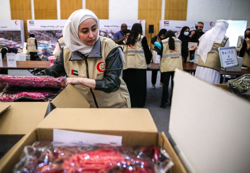 Volunteers pack boxes during the Emirates Red Crescent 'Bridges of Goodness' campaign, in support of Turkey and Syria, at the Adnec conference halls in Abu Dhabi. Victor Besa / The National