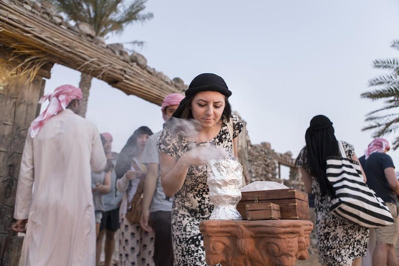 A woman draws in the scent of bukhoor at a desert camp site in Dubai. The tourism course will educate Emiratis in providing an ‘authentic experience’ to the visitors. Reem Mohammed / The National