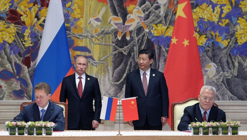 Russian and Chinese state energy company chiefs sign a supply agreement as the countries’ leaders look on.  Alexey Druginyn / RIA Novosti 