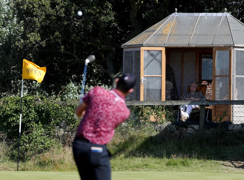 A spectator looks from a summer house next to the 4th green on Day 2 of The Open at Royal St George's, Sandwich, in England, on Friday, July 16.