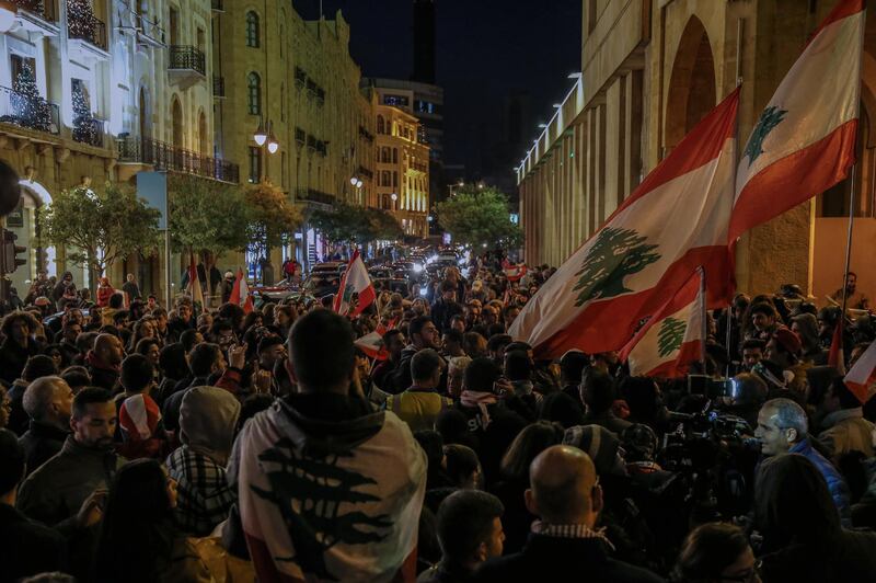 Protesters carry placards and wave Lebanese flags as they shout slogans against the parlianment members, during an anti-government protest in front of the Parliament building in Beirut.  EPA