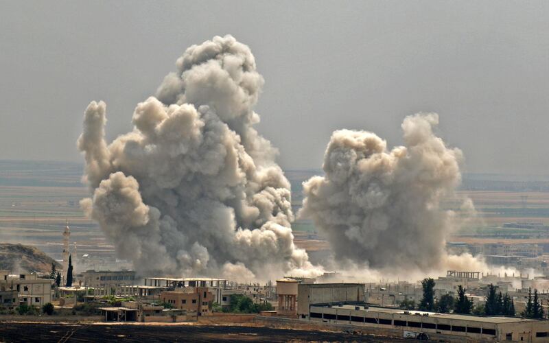 TOPSHOT - Plumes of smoke rise following reported Syrian government forces' bombardment on the town of Khan Sheikhun in the southern countryside of the jihadist-held Idlib province, on June 7, 2019. Fierce clashes between government forces and jihadists have left 83 combatants dead in northwestern Syria in the past 24 hours, a Britain-based war monitor said on June 7. / AFP / Anas AL-dyab
