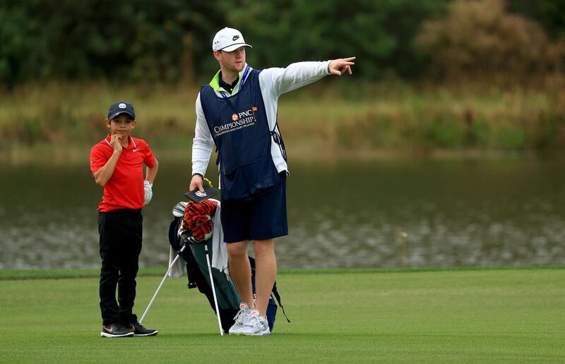 Charlie Woods lines up a putt with caddie Joe LaCava Jr. on the 15th hole during the final round of the PNC Championship at the Ritz Carlton Golf Club. AFP