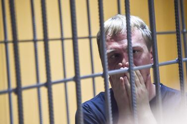 Russian investigative journalist Ivan Golunov sits inside the defendants' cage during a hearing at a court in Moscow on June 8, 2019. AFP