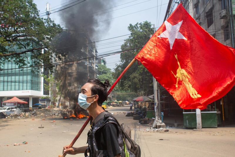 A man holds a National League for Democracy flag during a protest against the military coup in Yangon, Myanmar. Reuters