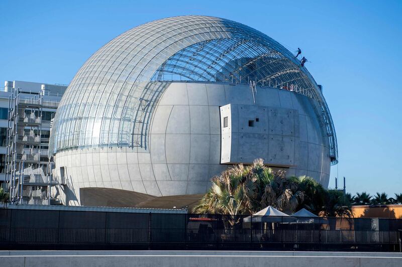 (FILES) In this file photo taken on October 14, 2020 workers clean the roof of the new Academy Museum of Motion Pictures, amid the coronavirus pandemic, in Los Angeles, California. The five songs nominated at this year's Oscars will be performed from the top of the Academy's gleaming new film museum -- and a tiny fishing town in Iceland -- as producers aim to shake up the format of the pandemic-hit ceremony to be held on April 25, 2021. / AFP / VALERIE MACON
