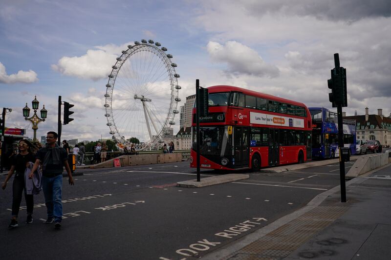 A double decker bus on Westminster Bridge, against the backdrop of the London Eye. AP