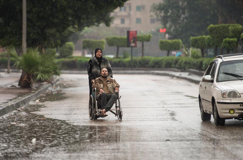 A woman pushes a man during a thunderstorm and heavy rains in Cairo. EPA