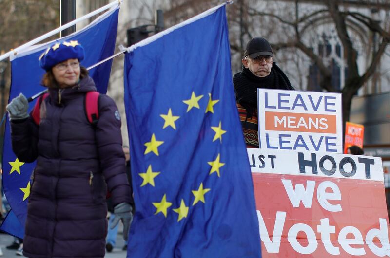 Anti-Brexit activists (L) and a pro-Brexit activist (R), hold placards and flags as they demonstrate near the Houses of Parliament in central London on January 28, 2019. Despite the humiliating rejection of Prime Minister Theresa May's Brexit deal, Britain is no closer to knowing the end result of its vote to leave the European Union. A raft of amendments to be voted on by MPs on Tuesday threaten to further muddy the waters as the clock ticks down to Britain's scheduled departure from the EU on March 29.
 / AFP / Tolga AKMEN
