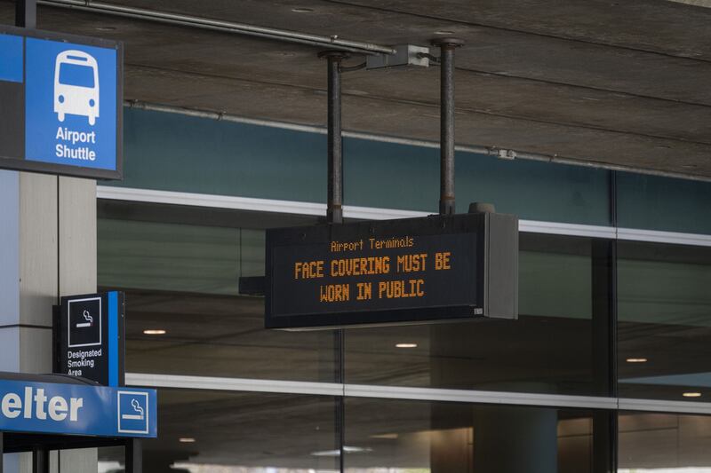 A sign urges passengers to wear masks at Logan International Airport in Boston, Massachusetts. Bloomberg