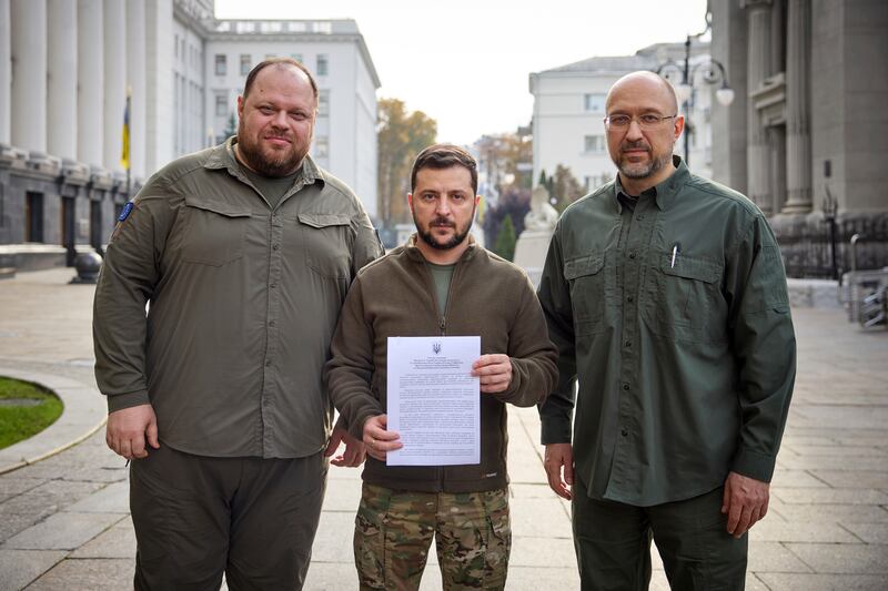 Ukrainian President Volodymyr Zelenskyy, with Prime Minister Denys Shmyhal and Chairman of Parliament Ruslan Stefanchuk, holds an application for accelerated accession to Nato. Ukrainian Presidential Press Office / AP