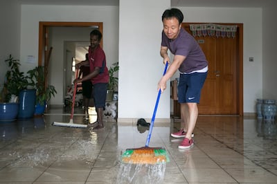 Dubai, United Arab Emirates.  March 11, 2016 /// Yoon Shik Ahn, a resident of the Green Community, tries to get rid of the water flowing over his house.  Residents of the Green Community come home to flooded homes.  Dubai, United Arab Emirates.  Mona Al Marzooqi/ The National ID: 63380 Reporter: Nicholas Webster Section: National *** Local Caption *** 160311-MM-Floodedhomes-012.JPG