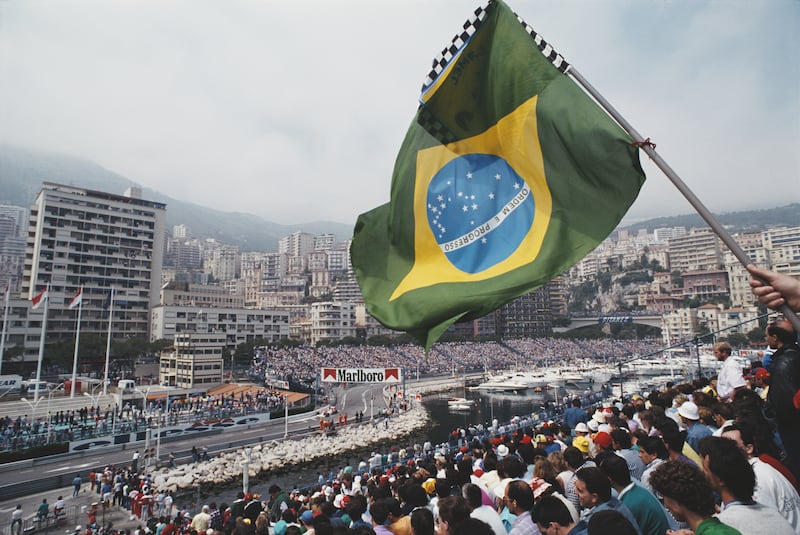 Spectators wave a Brazilian flag from the grandstand overlooking the harbour as Ayrton Senna of Brazil drives the #1 Honda Marlboro McLaren McLaren MP4-5 Honda V10 during the Grand Prix of Monaco on 7 May 1989 on the streets of the Principality of Monaco in Monte Carlo, Monaco. Getty Images