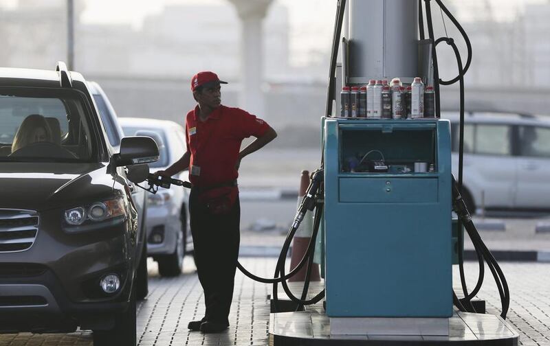A petrol station worker fill a motorist’s tank in Dubai. Kamran Jebreili / AP Photo