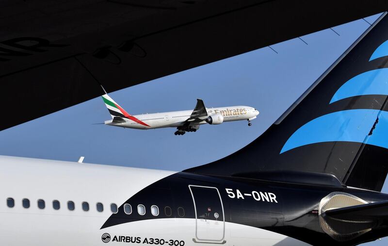 An Emirates Airline Boeing 777 aircraft is seen next to an Airbus A330-300 as it takes off from the Felix Houphouet-Boigny Airport in Abidjan on November 28, 2017. / AFP PHOTO / ISSOUF SANOGO