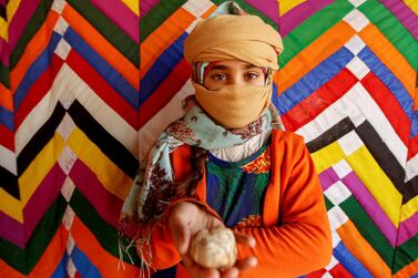 Salma Mohsen, 10, poses for a photo holding a truffle, in the desert in Samawa, Iraq, February 23, 2021. REUTERS/Alaa Al-Marjani SEARCH "TRUFFLES SAMAWA" FOR THIS STORY. SEARCH "WIDER IMAGE" FOR ALL STORIES