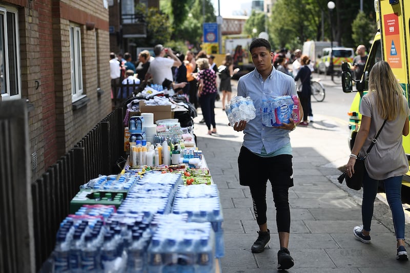 A man donating water to a stall set up to help people affected by the fire.  Getty Images