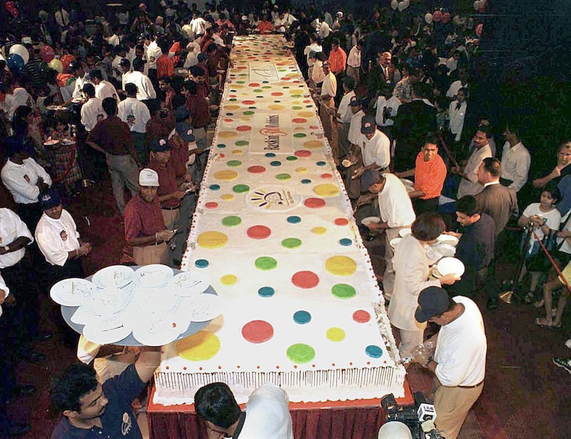 Some 2,000 people crowd around the "world's largest ice cream cake', on display at the Jumairah Beach hotel in Dubai, 14 July 1999.  Organizers hope the cake, which is 16 meters (53 feet) long and contains 6,000 liters of ice cream, will make it into the Guiness Book of World Records. 
 / AFP PHOTO / JORGE FERRARI