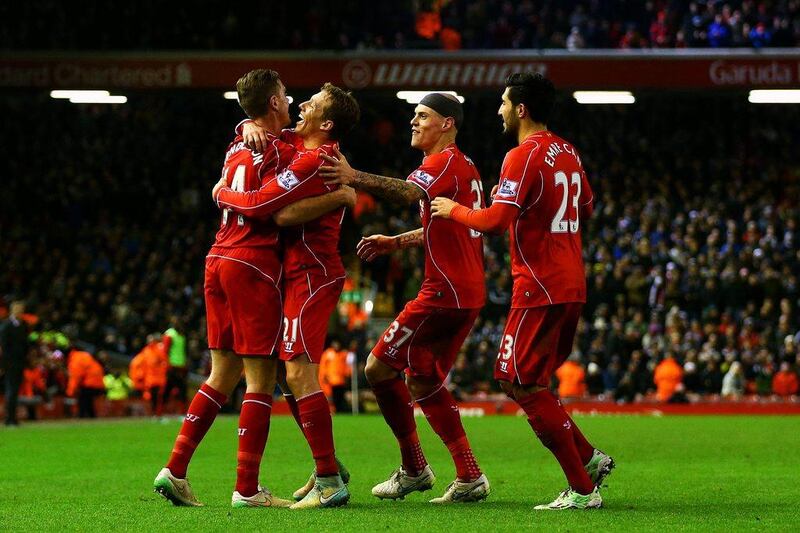 Jordan Henderson of Liverpool celebrates with teammates after Swansea City's Jonjo Shelvey scores an own goal in their Premier League contest on Monday night at Anfield. Clive Brunskill / Getty Images