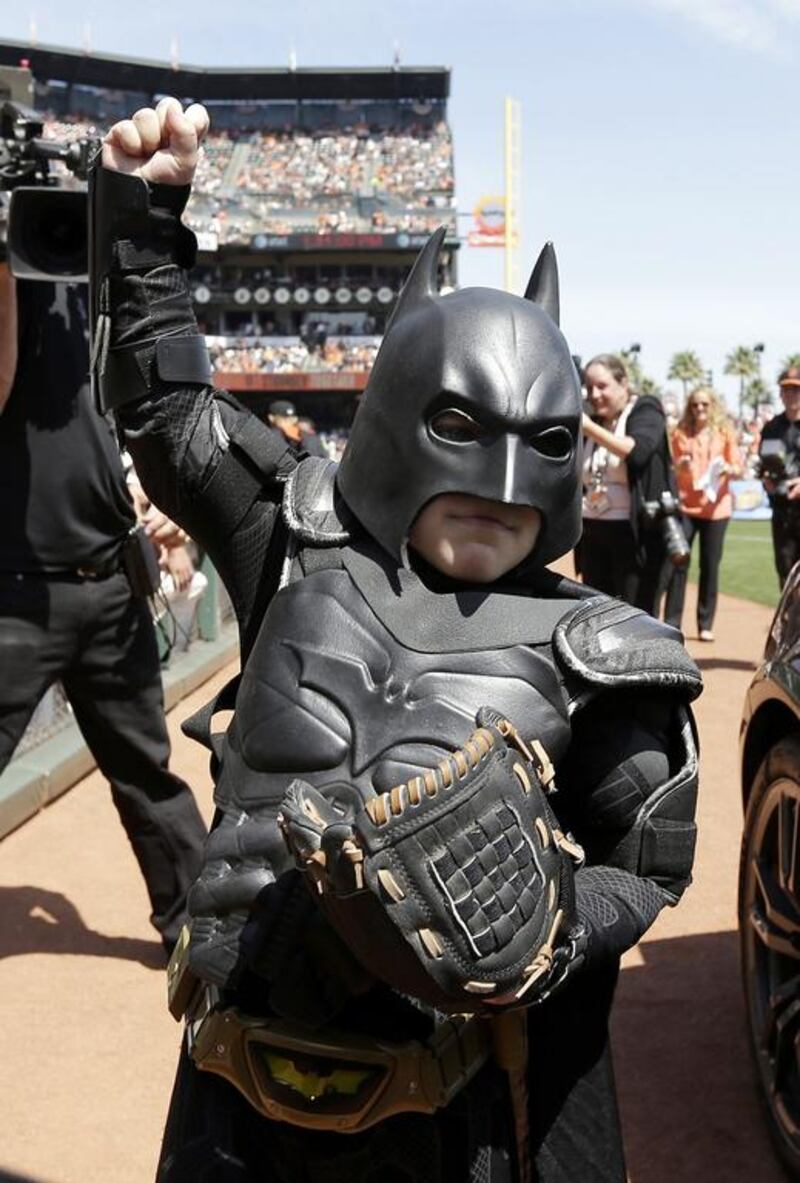 Miles Scott, dressed as Batkid, gestures after throwing the ceremonial first pitch before the San Francisco Giants play the Arizona Diamondbacks. Eric Risberg /AP