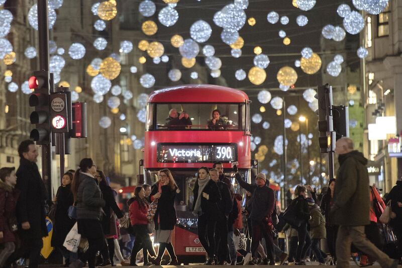 (FILES) This file photo taken on December 05, 2017 shows shoppers crossing in front of a London bus as it travels under Christmas lights on Oxford Street in central London.
British retailers faced a slowdown in sales over the crucial Christmas trading period, survey data showed on January 9, 2018, as shoppers were squeezed by higher prices and stagnating wages. / AFP PHOTO / Justin TALLIS