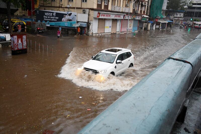 An Indian motorist pushes through a flooded street after heavy rainfall left by cyclone Tauktae's journey through the city of Mumbai. EPA