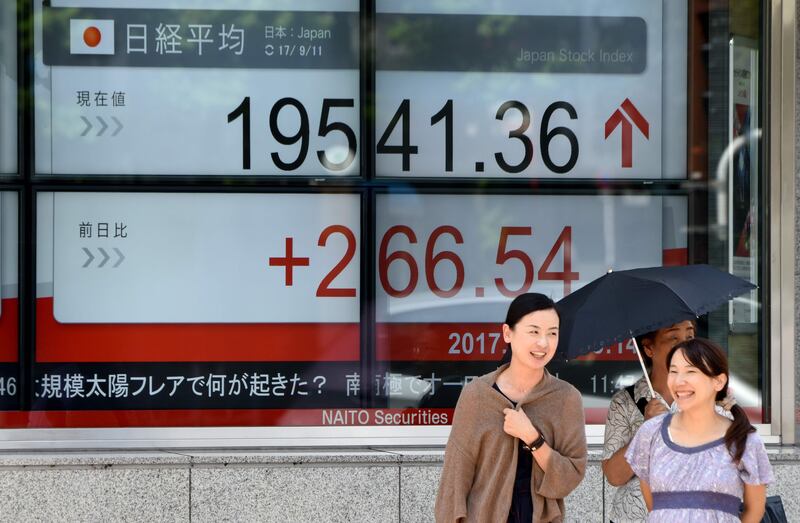 Pedestrians wait for a green light beside a stock quotation board flashing the Nikkei 225 key index of the Tokyo Stock Exchange in front of a securities company in Tokyo on September 11, 2017.

Tokyo stocks rallied on upbeat Japanese data and a weaker yen, with the North Korea crisis in focus as the US pushes for tough new sanctions against the nuclear-armed state. / AFP PHOTO / Toru YAMANAKA