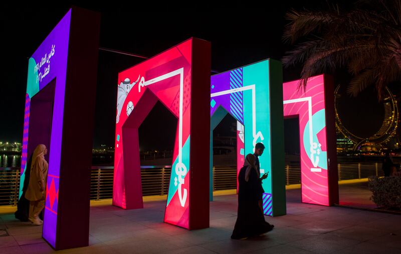 People walk past FIFA World Cup banners at Lusail Marina Promenade in Doha, Qatar.  The FIFA World Cup Qatar 2022 will take place from 20 November to 18 December 2022 in Qatar. EPA