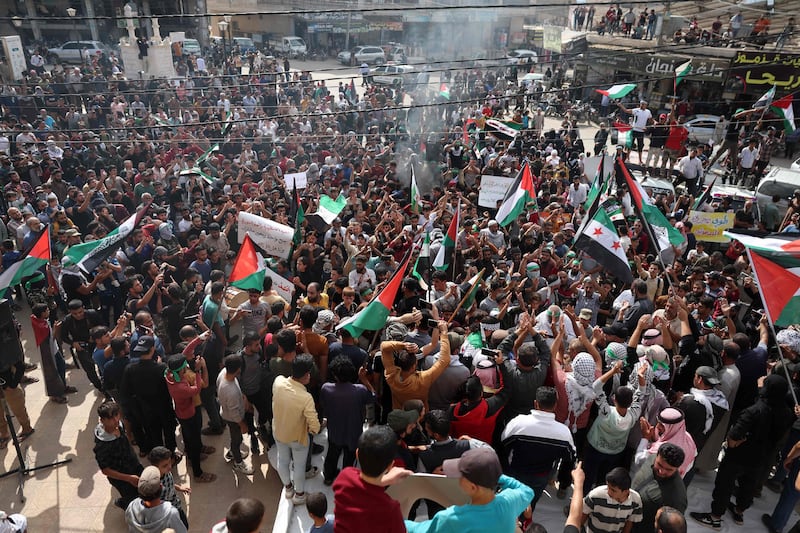 Protesters wave Palestinian and Syrian opposition flags in support of Gaza residents, in the rebel-held town of Atme in Syria's Idlib province. AFP