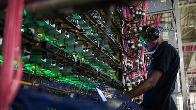 A technician monitors cryptocurrency mining rigs in Quebec, Canada. Bloomberg