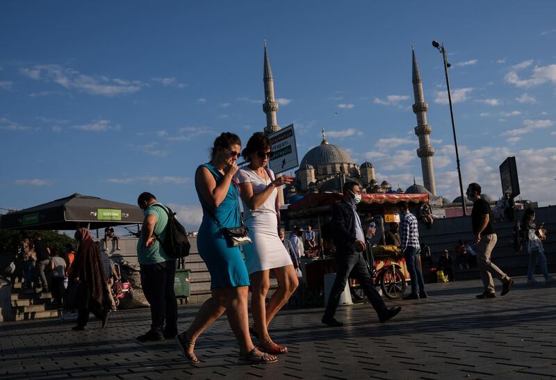 People wear face masks as they walk in front of the Yeni Mosque near Eminonu local bazaar, in Istanbul, Turkey. Turkish authorities have now allowed the reopening of restaurants, cafes, parks and beaches, as well as lifting the ban on inter-city travel, as the country eases the restrictions it had imposed in a bid to stem the spread of the ongoing pandemic of the COVID-19 disease caused by the SARS-CoV-2 coronavirus.  EPA
