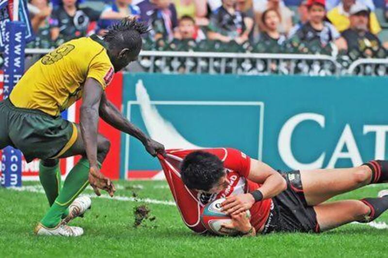 Andrew Hylton, left, and his Jamaica teammates had a hard time against Asia power Japan and Kazushi Hano at the Hong Kong Sevens tournament.