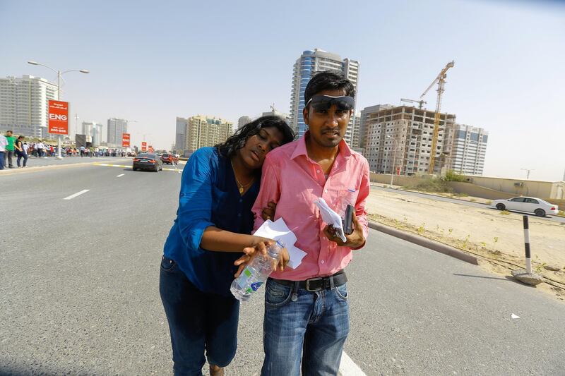 Dubai, U.A.E., July 17,  2015.   Too hot to handle.  Young Woman loyalists  of Modi, who fainted due to the heat at Dubai Cricket Stadium.   Victor Besa for The National. *** Local Caption ***  VB_17-05-15_Modi-19.jpg