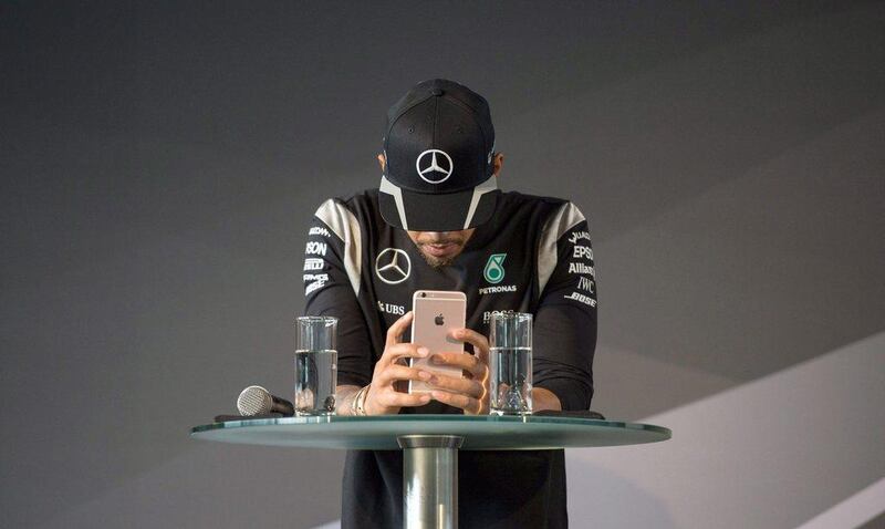 epaselect epa05206124 British Formula One driver Lewis Hamilton of Mercedes looks at his iPhone while attending a press conference on the occasion of the start of the new racing season in Fellbach, Germany, 11 March 2016. The 2016 Formula One season starts on 20 March 2016 in Australia.  EPA/Marijan Murat