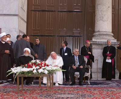 Syria's great Mufti Sheikh Ahmad Kuftaro, seated left, meets Pope John Paul II, seated center, at the Omayyad mosque compound in Damascus' old city were the tomb of Saint John the Baptist is located Sunday, May 6, 2001. Before 636 A.D. the mosque was a church. It is the first time in history that a Pope sets foot in a mosque. Others are unidentified. (AP Photo/SANA)