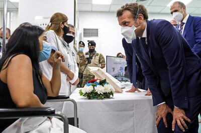 French President Emmanuel Macron speaks to a patient as he visits the Rafik Hariri University Hospital in the presence of Lebanese Health Minister Hamad Hassan in Beirut, on September 1, 2020. / AFP / POOL / Stephane LEMOUTON
