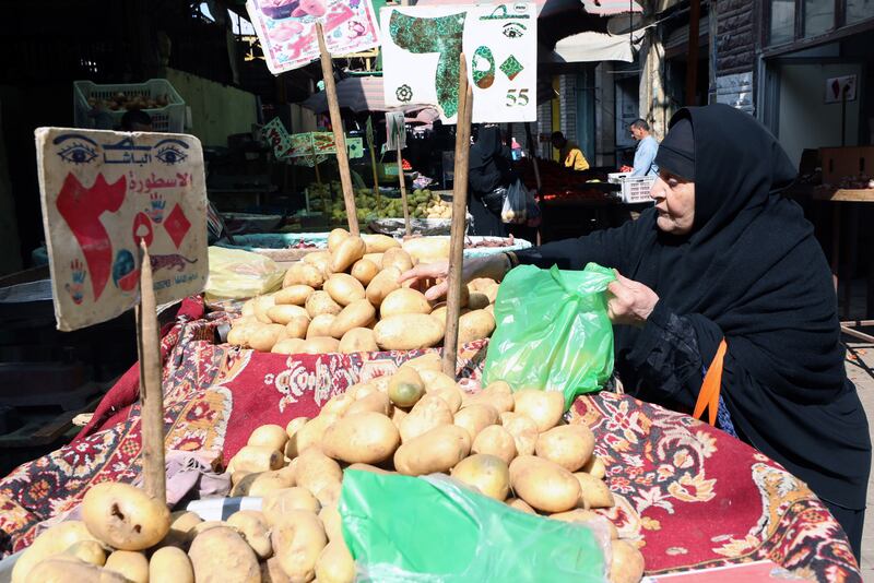 A woman buys potatoes at a market in the Abdeen district of Cairo, Egypt. EPA