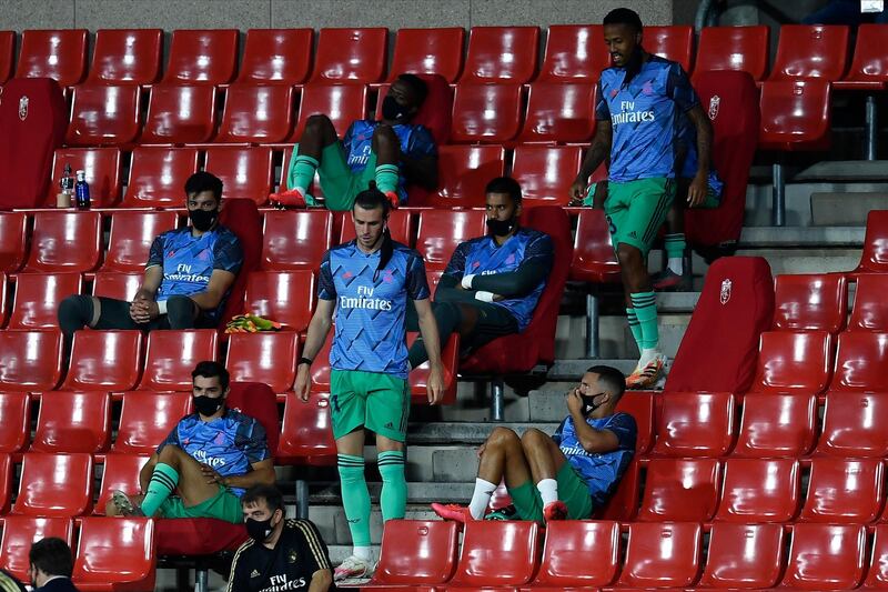 Real Madrid substitutes sit in the stands during the match against Granada. AP Photo