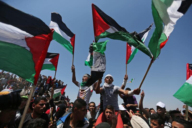 Demonstrators hold Palestinian flags during a protest marking the 71st anniversary of the 'Nakba' near the Israel-Gaza border fence. Reuters