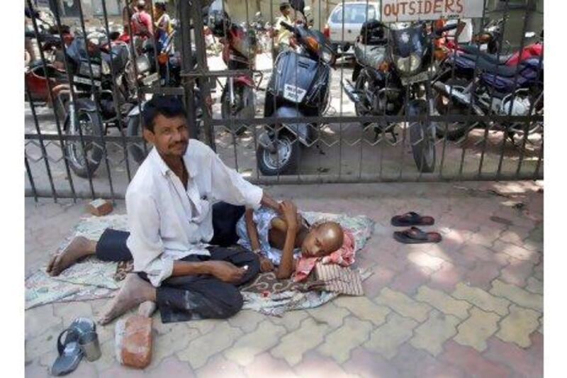 Cancer patient Rajkishore, gets a massage from a relative, outside Tata cancer hospital, in Mumbai, Indiia.  India's Supreme Court on on  Monday dismissed Swiss drugmaker Novartis's  appeal seeking patent protection for its popular leukemia drug Glivec.