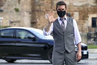 Tom Cruise, wearing a face mask, waves on the set of 'Mission Impossible 7' in Rome in October 2020. Getty Images 