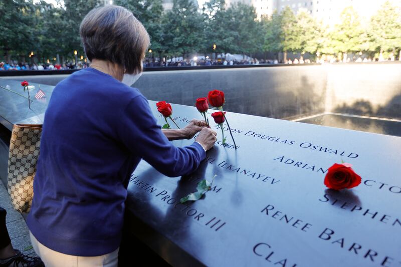 A woman places flowers on the 9/11 memorial. EPA