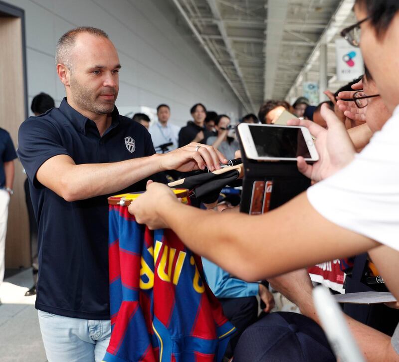 Andres Iniesta signs an autograph for a fan upon arrival at Kansai International Airport. Shohei Miyano / AP Photo