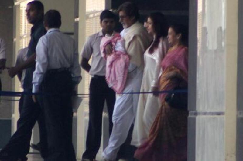 Amitabh Bachchan carries his new granddaughter out of Seven Hills hospital in Mumbai yesterday as the baby’s mother, Aishwarya Rai, follows. AFP