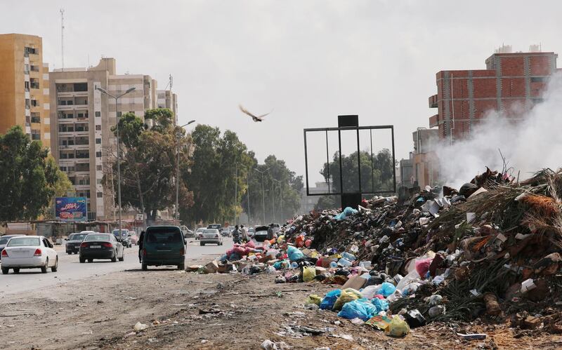 Cars pass next to the mounds of rubbish in Tripoli, Libya. Reuters