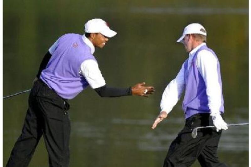 Tiger Woods, left, celebrates with partner Steve Stricker during the opening round of fourballs at Celtic Manor golf course in Wales yesterday.