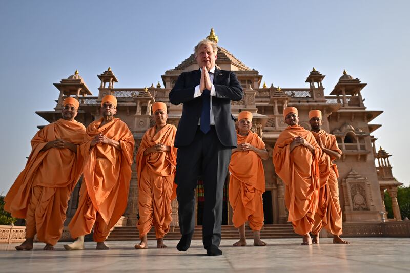 British Prime Minister Boris Johnson poses with sadhus, or Hindu holy men, in front of the Swaminarayan Akshardham temple in Gandhinagar during his two-day trip to India. Getty Images